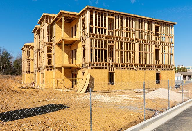 a construction site enclosed by temporary chain link fences, ensuring safety for workers and pedestrians in Walnut Grove, AL